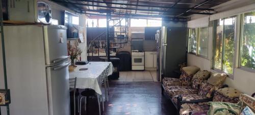 a kitchen with couches and a refrigerator in a room at Habitacion Donde Emita in Santiago