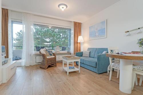 a living room with a blue couch and a window at Haus Baltic Traumfabrik in Scharbeutz