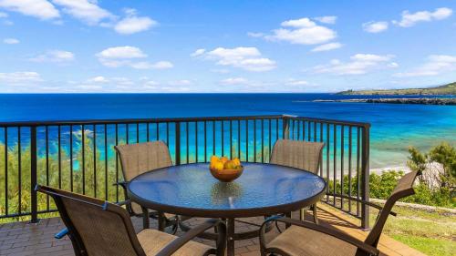 a table on a balcony with a bowl of fruit on it at Kapalua Bay Villa 21G2 in Kapalua