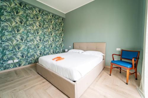 Un dormitorio con una cama y una silla azul. en Tiber Domus Fiumicino - Apt 6, en Fiumicino