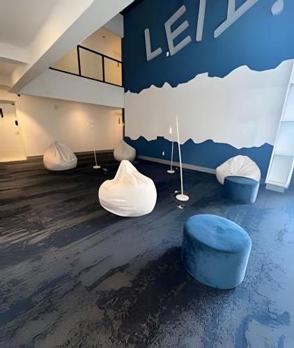 a room with white furniture and a blue wall at Excelente e confortável Flat in Goiânia