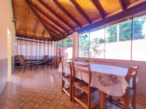 a dining room with a table and chairs and windows at Haus Independencia Guara Paraguay in Colonia Catorce de Mayo