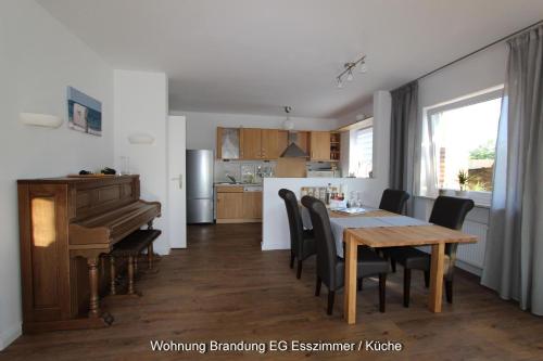 a kitchen and dining room with a table and a piano at Kampenweg 8 Brandung in Puttgarden