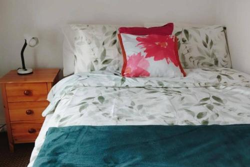 - un lit blanc avec un oreiller rouge et une table de nuit dans l'établissement Cosy Cork - House - Sleeps 4 - City Centre, à Cork