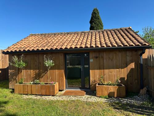 une petite maison avec deux jardinières devant dans l'établissement La Cabane du Mascaret, à Vayres