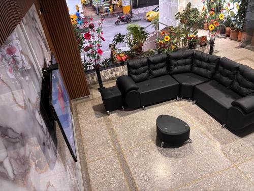 a black couch and a ottoman in a room at Hotel Los Arcangeles in Cúcuta