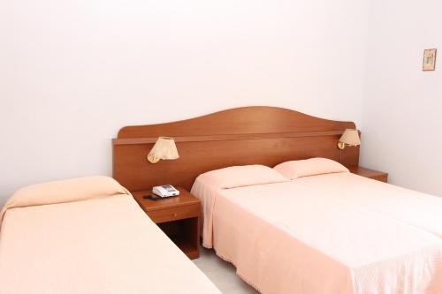 a bedroom with two beds and a nightstand with two beds at Castelvetere Hotel in Caulonia