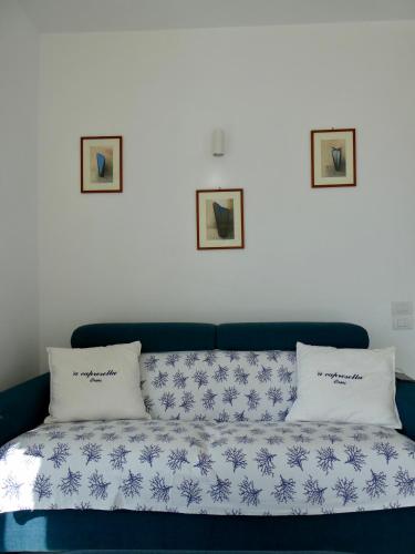 a blue couch with two pillows on top of it at Capresella luxury apartment in Capri