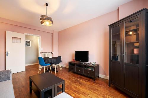 un salon avec une télévision et une table dans l'établissement Colombier - Appartement 2 chambres - Proche gare, à Rennes