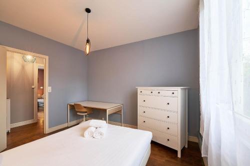 - une chambre avec un lit, un bureau et une commode dans l'établissement Colombier - Appartement 2 chambres - Proche gare, à Rennes