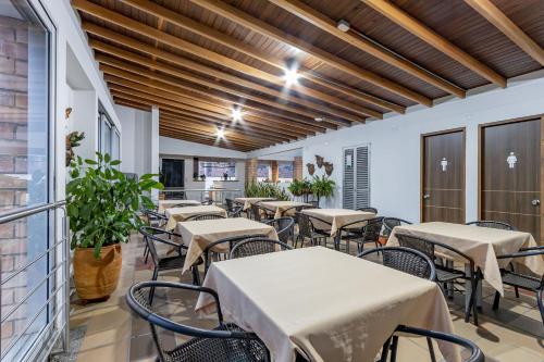 a dining room with tables and chairs and wooden ceilings at Hotel Prada in Bello