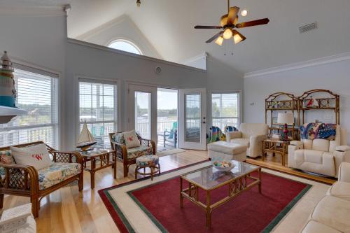 a living room with white furniture and a ceiling fan at Fish, Boat and Unwind Creekside Oasis in Darien! in Darien