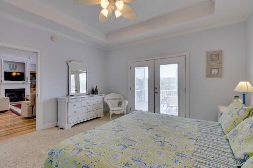 a white bedroom with a bed and a dresser and a mirror at Fish, Boat and Unwind Creekside Oasis in Darien! in Darien
