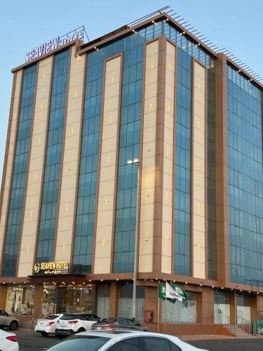 a large glass building with cars parked in a parking lot at SEAVIEW HOTEL in Umm Lujj