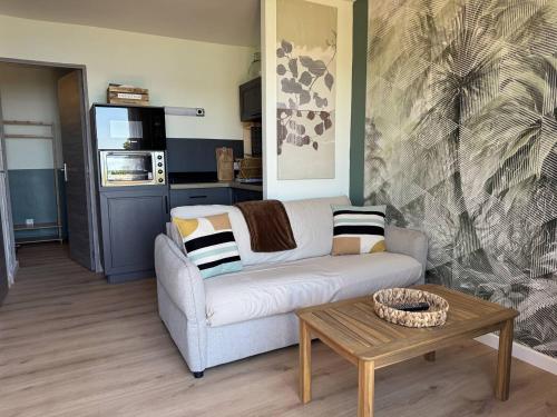 un salon avec un canapé et une table basse dans l'établissement Les Floralies à Saint-Clair, au Lavandou