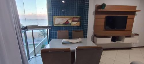 a room with a table with chairs and a television at Apartamento vila velha in Vila Velha
