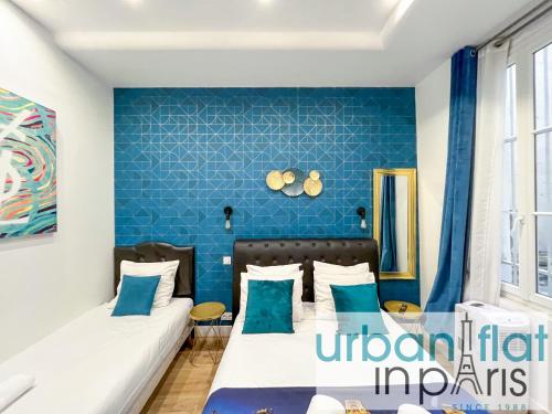 une chambre avec deux lits et un mur bleu dans l'établissement Urban Flat 156 - YSL Saint Denis, à Paris