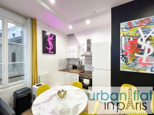 une cuisine et une salle à manger avec une table et des chaises jaunes dans l'établissement Urban Flat 156 - YSL Saint Denis, à Paris