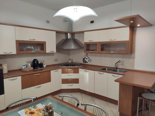 a kitchen with white cabinets and a sink and a table at Wilma House in Venice