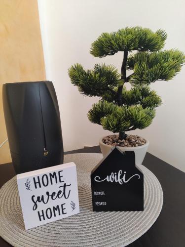 a home sweet home sign next to a bonsai tree at Wilma House in Venice