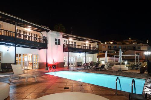 a swimming pool in front of a hotel at night at Villa Magnificent 5-star with sea view, jacuzzi and pool in Arguineguín