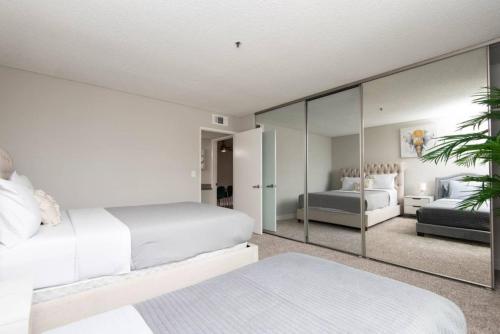 a bedroom with two beds and a mirror at Snazzy 2 Bedroom Pad with Rooftop Pool and Hollywood Sign View in Los Angeles