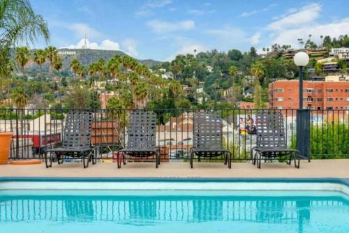 a group of chairs sitting next to a swimming pool at Snazzy 2 Bedroom Pad with Rooftop Pool and Hollywood Sign View in Los Angeles