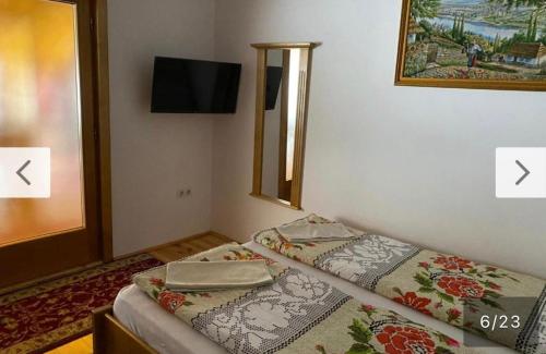 a small bedroom with two beds and a mirror at Camere de închiriat Floarea Reginei in Vişeu de Sus