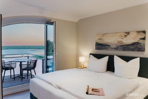 a bedroom with a large bed and a balcony at Lütt Diekje in Westermarkelsdorf