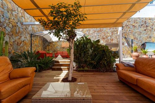 a living room with orange furniture and a tree at Villa Magnificent 5-star with sea view, jacuzzi and pool in Arguineguín