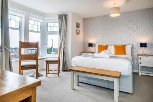 a bedroom with a large bed and a desk and a table at Redlands House By Urban Hideaways in Barry