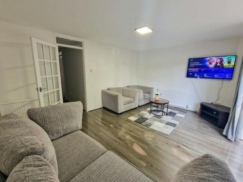 a living room with two couches and a flat screen tv at 3 Bedroom Northenden Home by City SuperHost in Wythenshawe