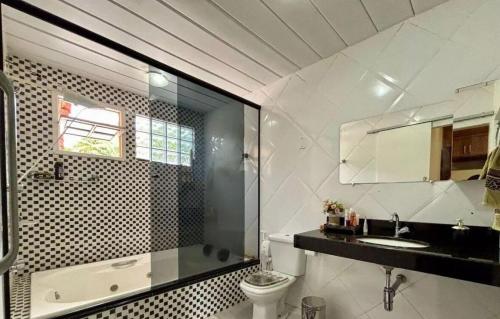 a bathroom with a shower and a toilet and a sink at Sitio Julimari in Itabirito