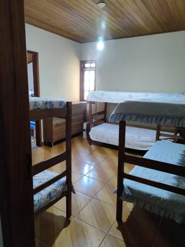 a room with three bunk beds and a window at Sitio Julimari in Itabirito