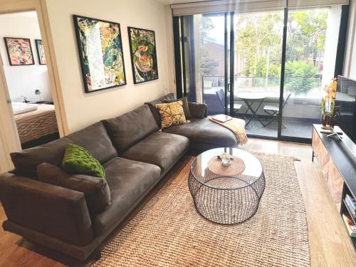 a living room with a brown couch and a table at Cosmo Stays- Boutique Apartment Perfect Location in Melbourne