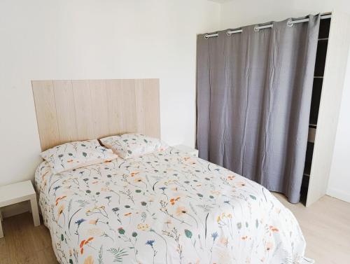 a bedroom with a bed with a comforter and a window at Appartement 3 chambres à Sedan in Sedan