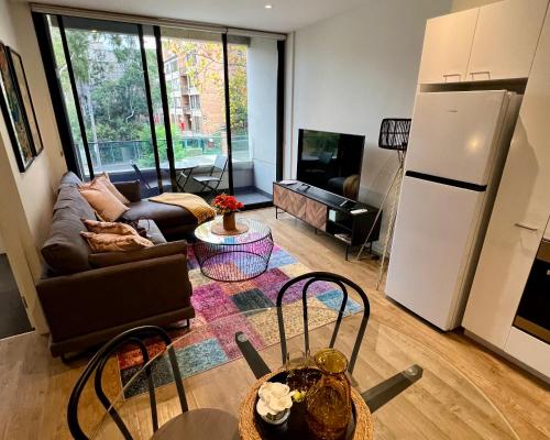 a living room with a couch and a refrigerator at Cosmo Stays- Boutique Apartment Perfect Location in Melbourne