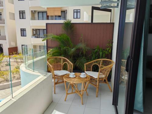 a patio with chairs and a table on a balcony at Luxury Seaview Apartment Flic en Flac CFF07 in Flic-en-Flac