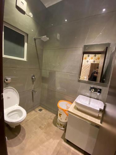 a bathroom with a toilet and a sink and a mirror at Hotel Blossom Inn in Amritsar