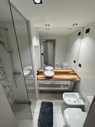 a bathroom with two sinks and a shower and two toilets at Faz Flat in Córdoba