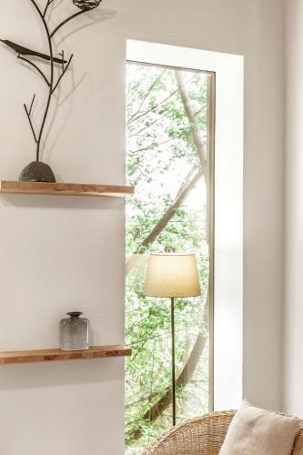 a living room with a window and a lamp at Biohotel Gralhof in Weissensee