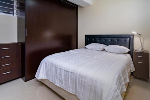a bedroom with a large bed with a wooden headboard at Alojamiento Lecheria PV1 in El Morro de Barcelona