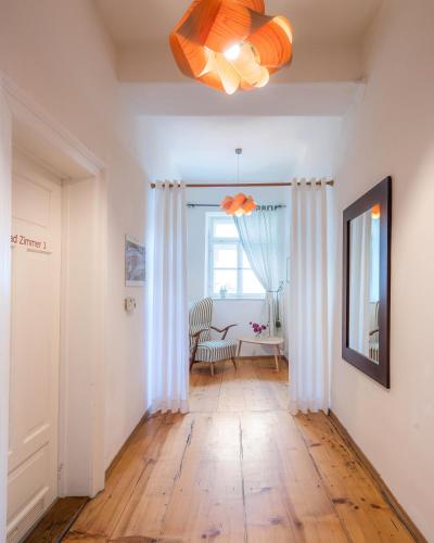 a room with a hallway with a table and a chandelier at Pension Goldenes Schiff in Passau