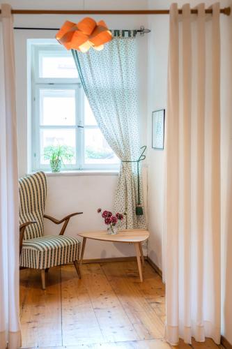 a living room with a chair and a table and a window at Pension Goldenes Schiff in Passau