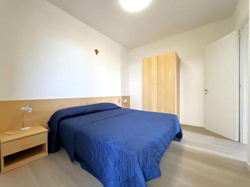 Un dormitorio con una cama azul y una mesita de noche. en Corso - Appartamenti, en Bibione