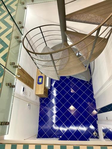 a spiral staircase in a room with blue tiled floors at La Casa del Capitano in Amalfi