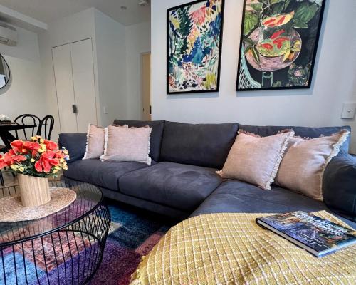 a living room with a couch and a table at Cosmo Stays- Boutique Apartment Perfect Location in Melbourne