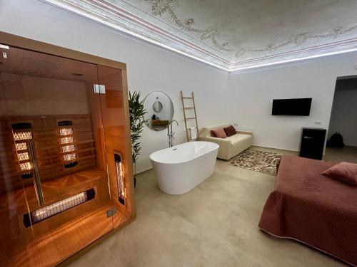 a bathroom with a tub and a couch and a television at Massimo Rooms and suite in Palermo