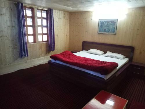 Un dormitorio con una cama con una manta roja. en The Royal Villa, en Matiāna