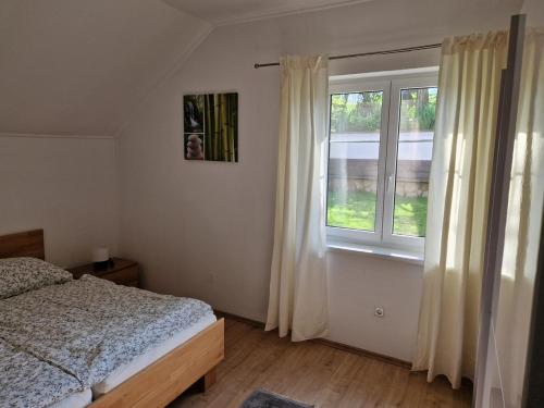 a bedroom with a bed and a large window at Apartment Schlossblick in Loosdorf